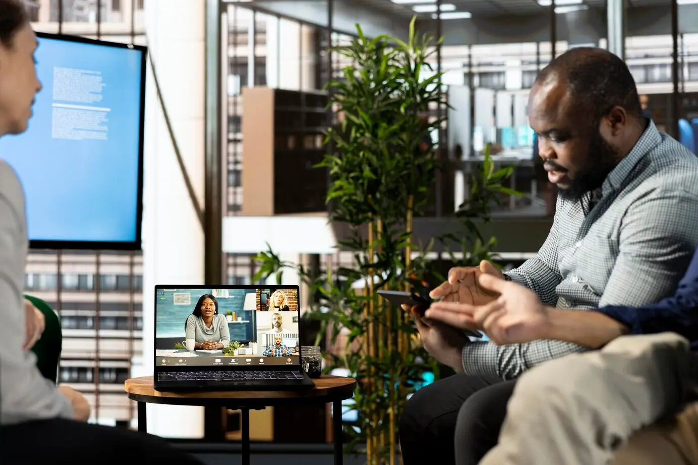 Ein Mann führt im Büro des Unternehmens einen Videoanruf mit Kollegen.